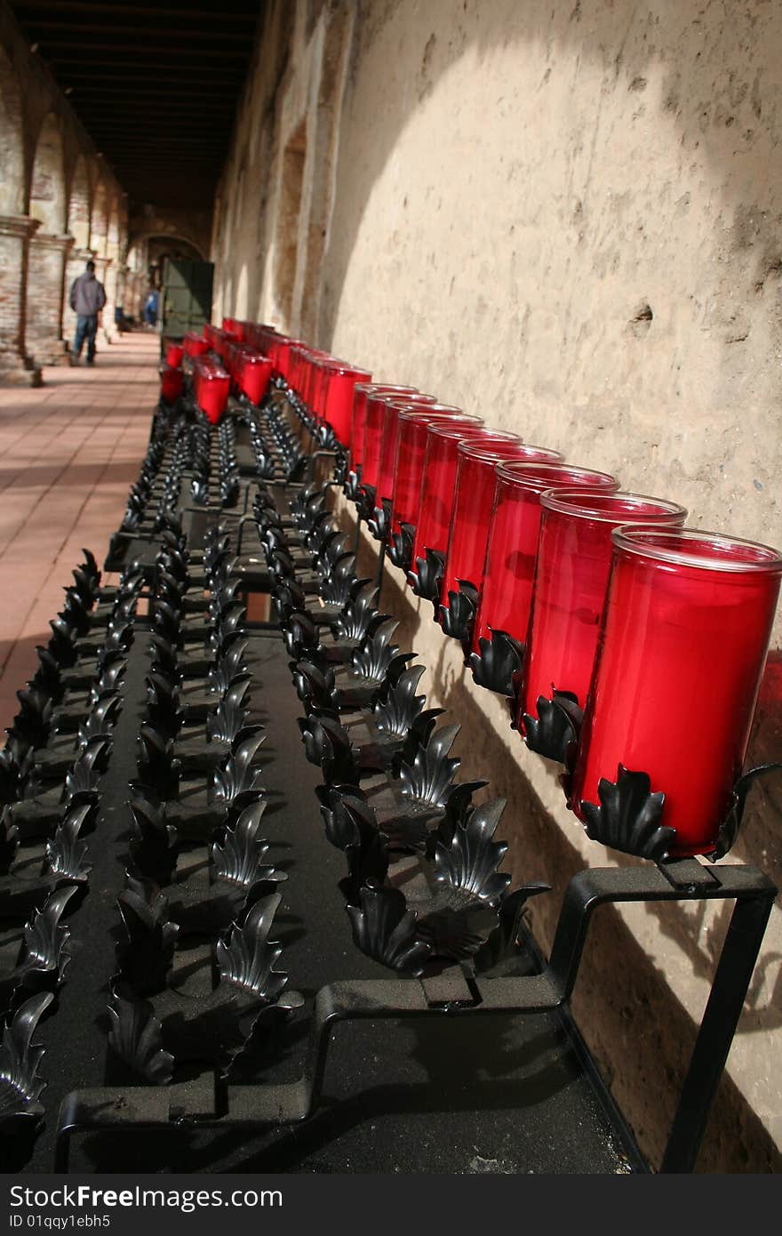 Shot of red candles in front of a mission chapel in California. Shot of red candles in front of a mission chapel in California