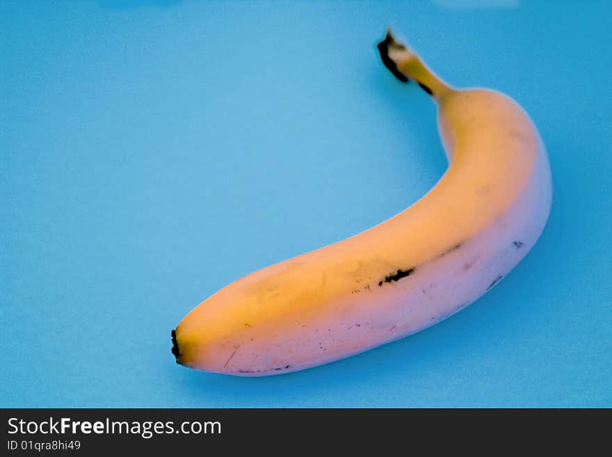 It's a single banana against a light aqua blue background. It's a single banana against a light aqua blue background