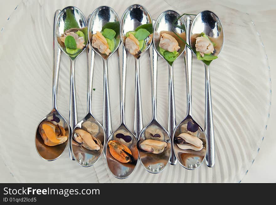 Mussel and arranged in a very stilish composition on a spoon. Mussel and arranged in a very stilish composition on a spoon