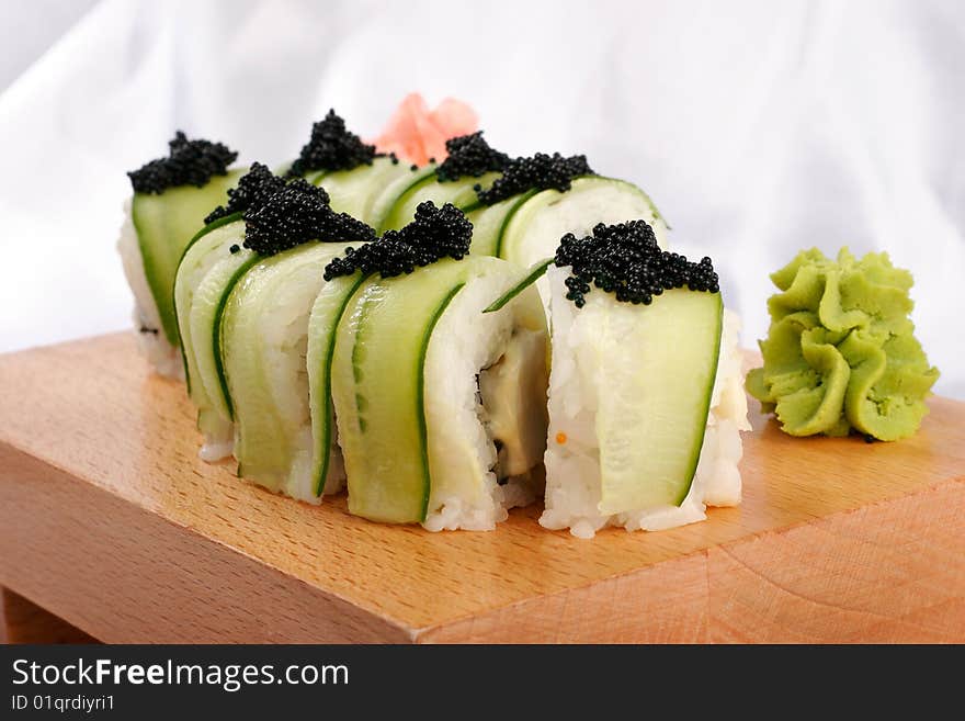 Shushi and black caviar on wood plate