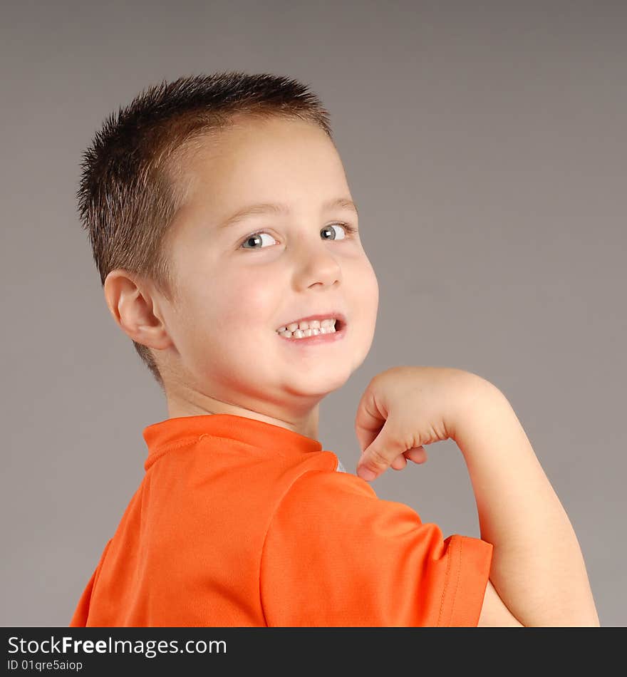 Cute little boy showing off his muscles. Cute little boy showing off his muscles