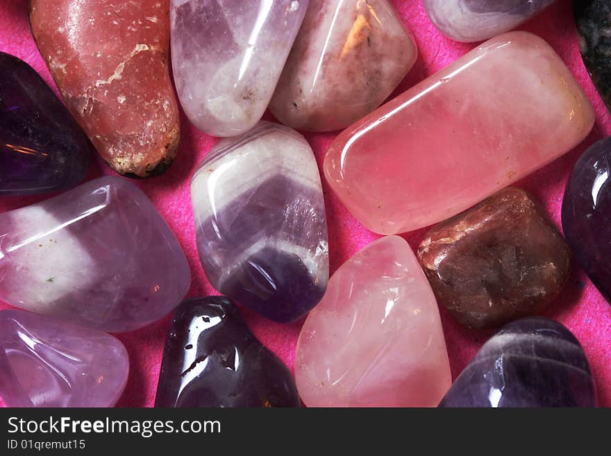 A macro photo of pink and violet polished stones