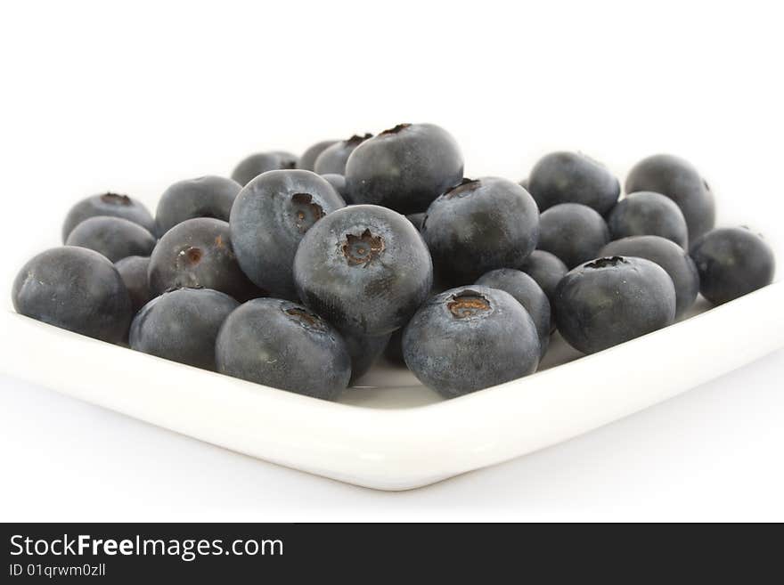 A plate with fresh blueberries isolated on white background, with shadow.