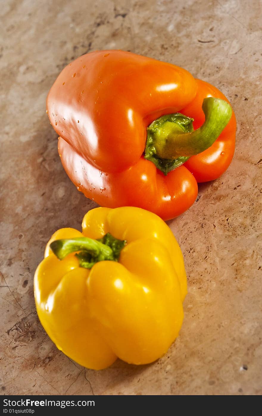 Yellow and orange paprika on a stone counter