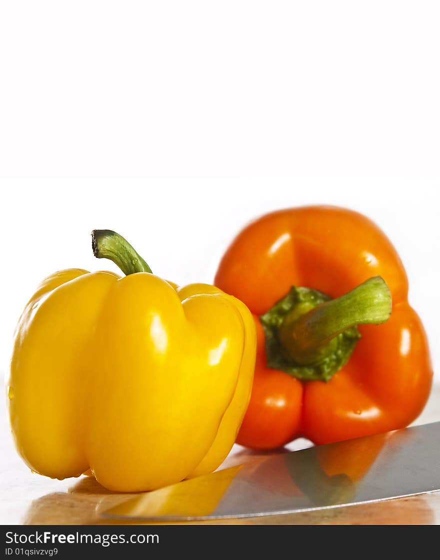 Yellow and orange paprika on a stone counter