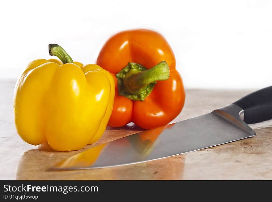 Yellow and orange paprika on a stone counter