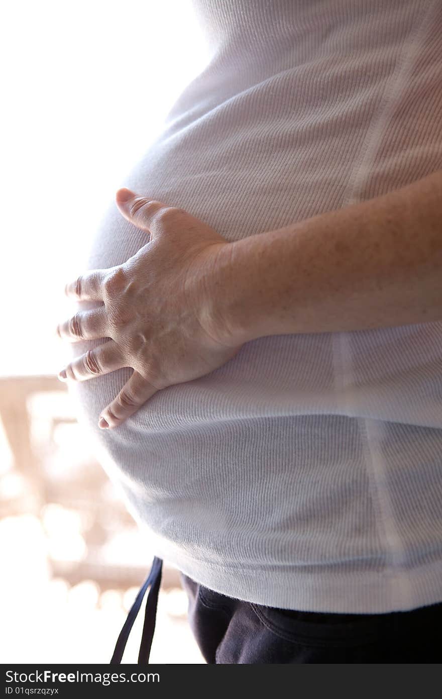 A Pregnant woman expecting a baby with a full belly