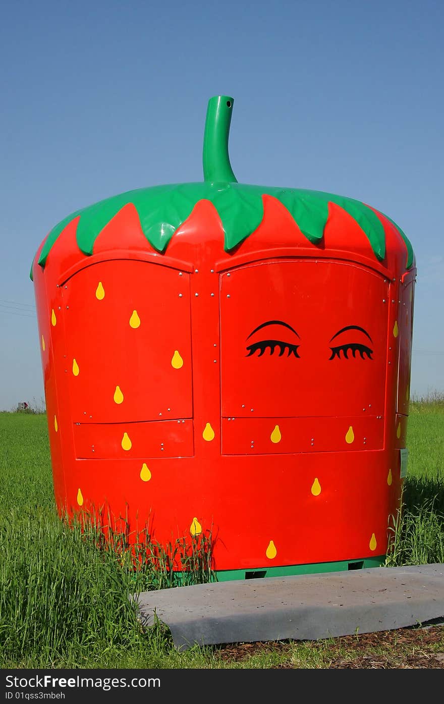 A market stand for selling strawberries photographed in the early summer sun next to a commercial acre