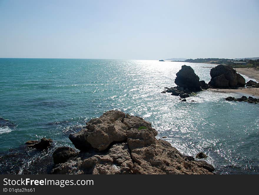 Rocky beach on a sunny day with crystal clear blue sea