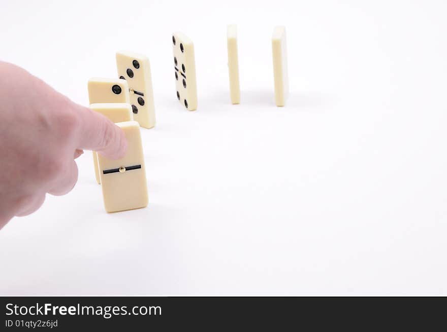 Hand causing dominoes to fall. Hand causing dominoes to fall