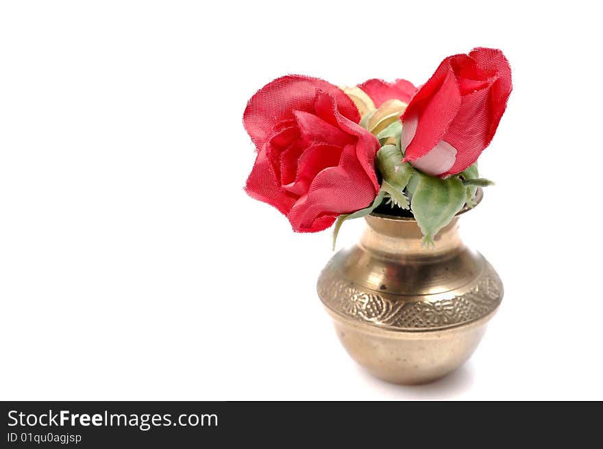 Artificial flowers in copper vessel.