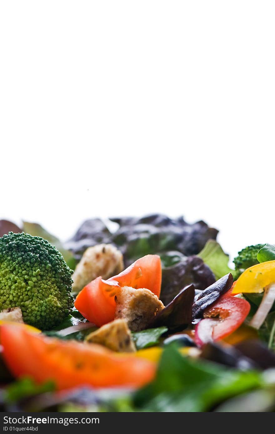 A healthy salad on the bottom of the frame isolated on white with room for text.