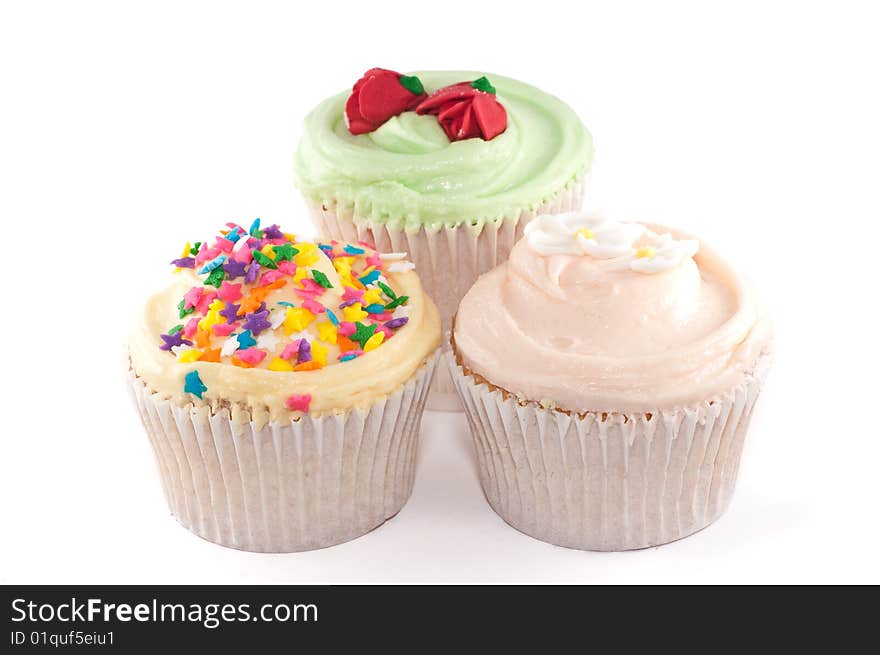 A small group of cupcakes with lovely decorations, isolated on a white background