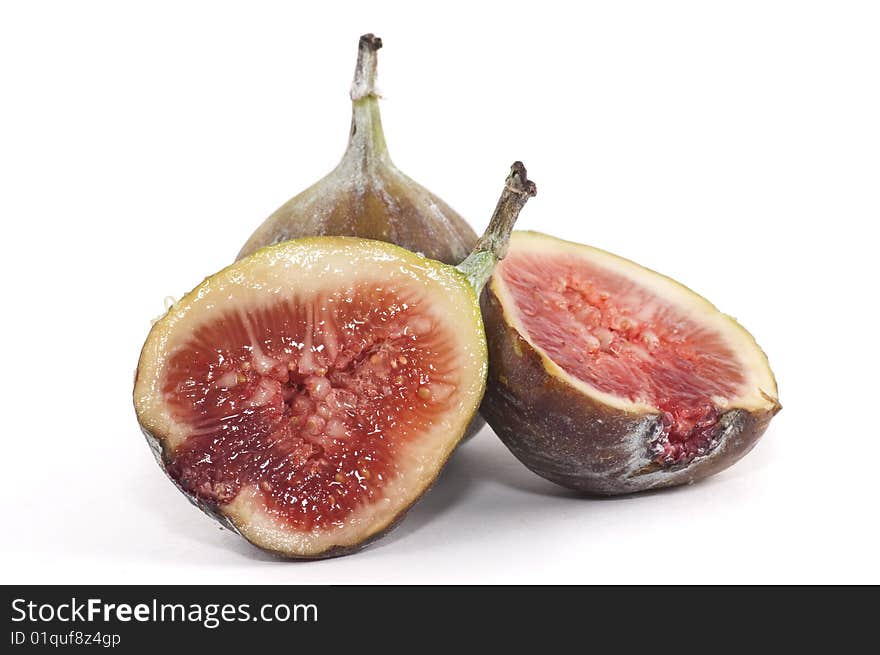 A two figs isolated on a white background, one is sliced in half.