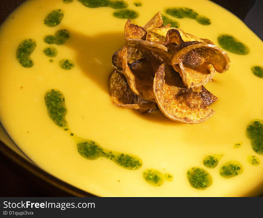 Yellow soup cream with potato chip