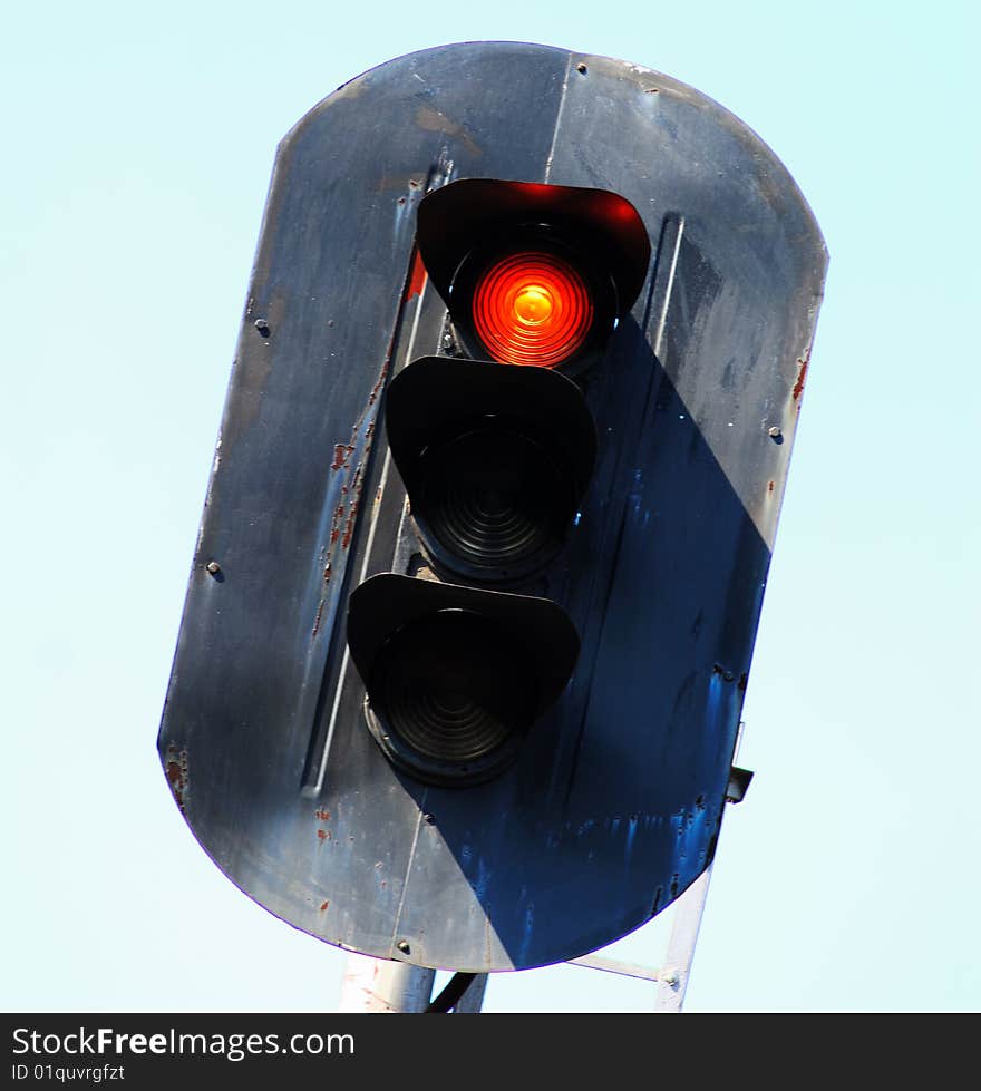 Old railway traffic light with  included red signal on  background of  sky