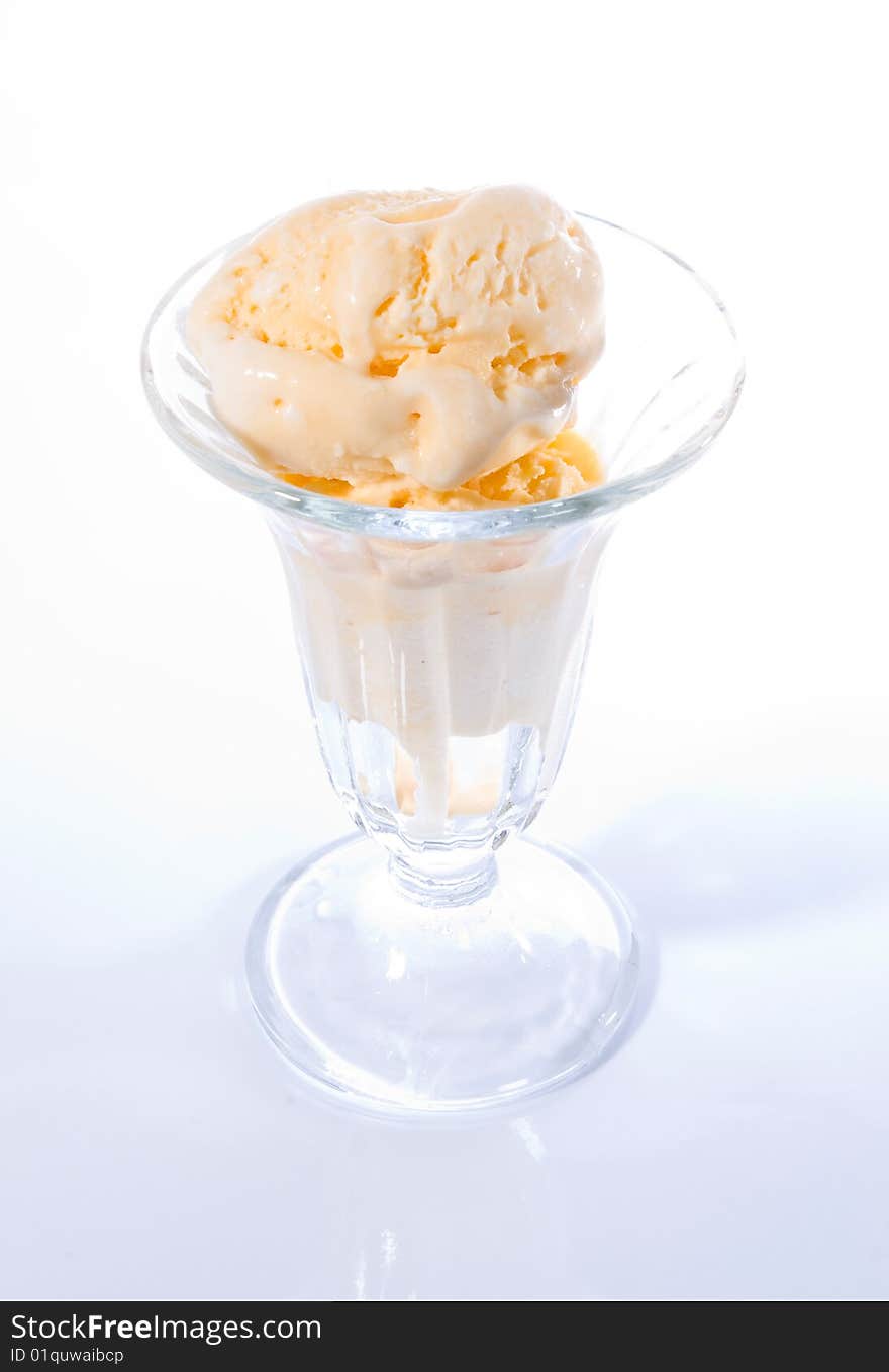 Vanilla ice cream in glass parfait cup. Hi-key photo with white background and only the contours of the cup visible. Vanilla ice cream in glass parfait cup. Hi-key photo with white background and only the contours of the cup visible.