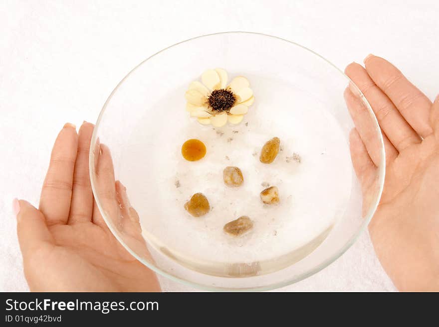 Female hands hold a cup with the salt cosmetic solution, isolated