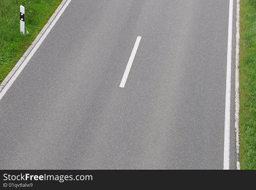 Single tracked road with roadside marker and middle line