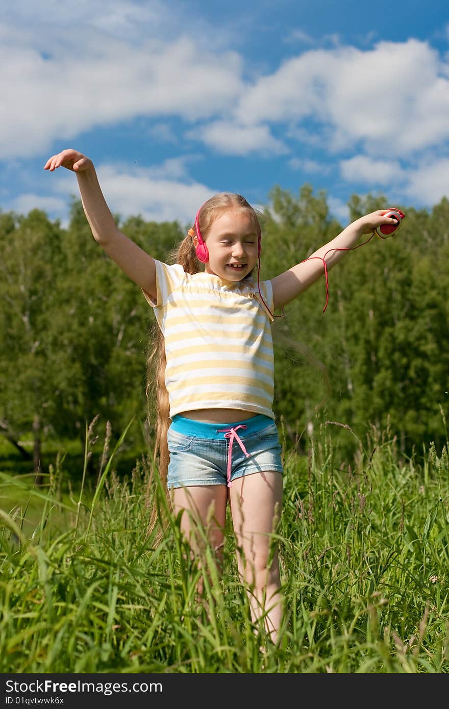 Blonde little girl with closed eyes in red earphones is listening mp3 player music and dancing. Blonde little girl with closed eyes in red earphones is listening mp3 player music and dancing