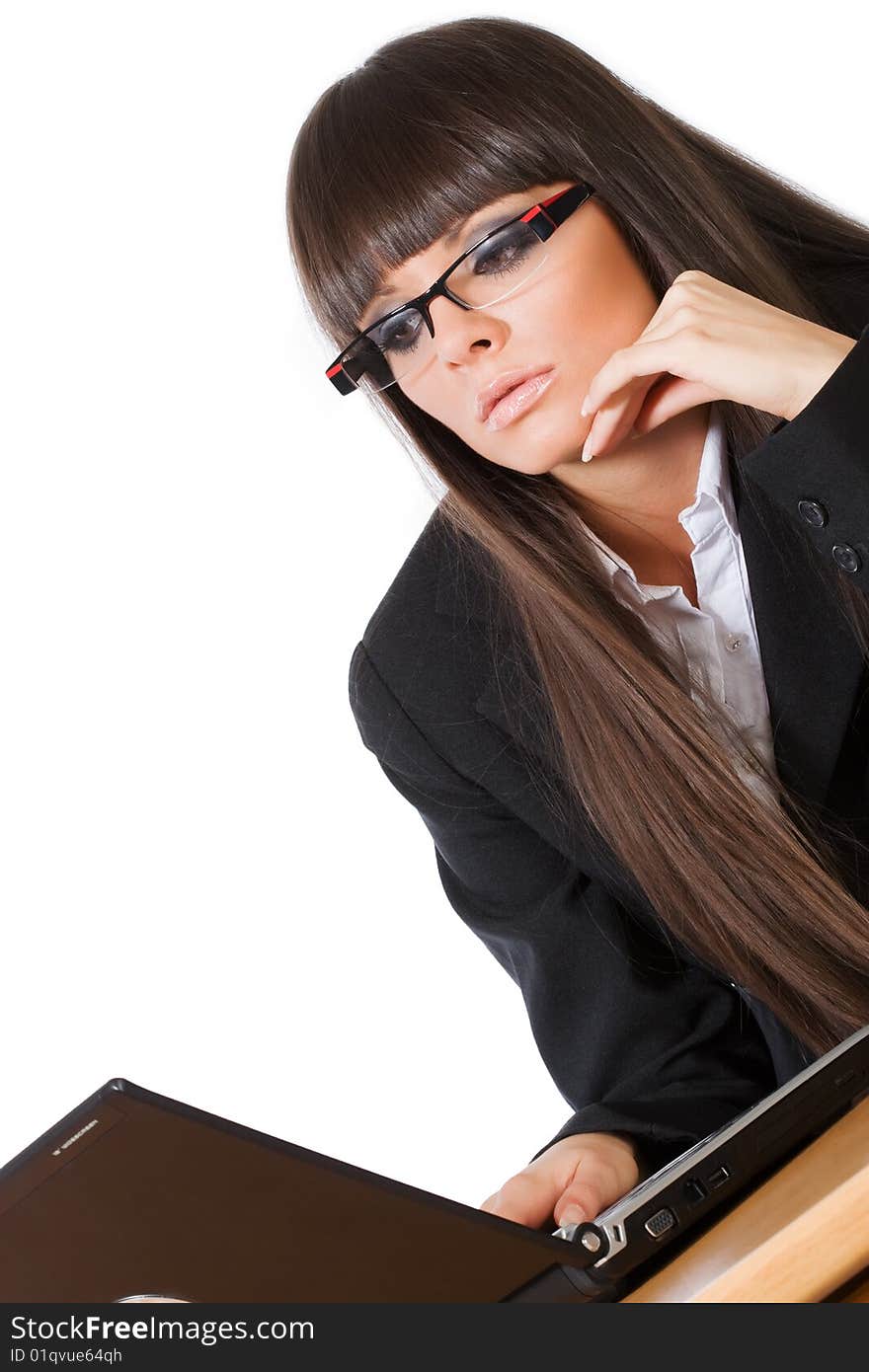 Beautiful brunette business girl working on her laptop computer shot diagonally, isolated on white