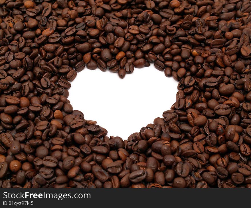 A crowd of coffee beans shows a heart-shape (white background). A crowd of coffee beans shows a heart-shape (white background)