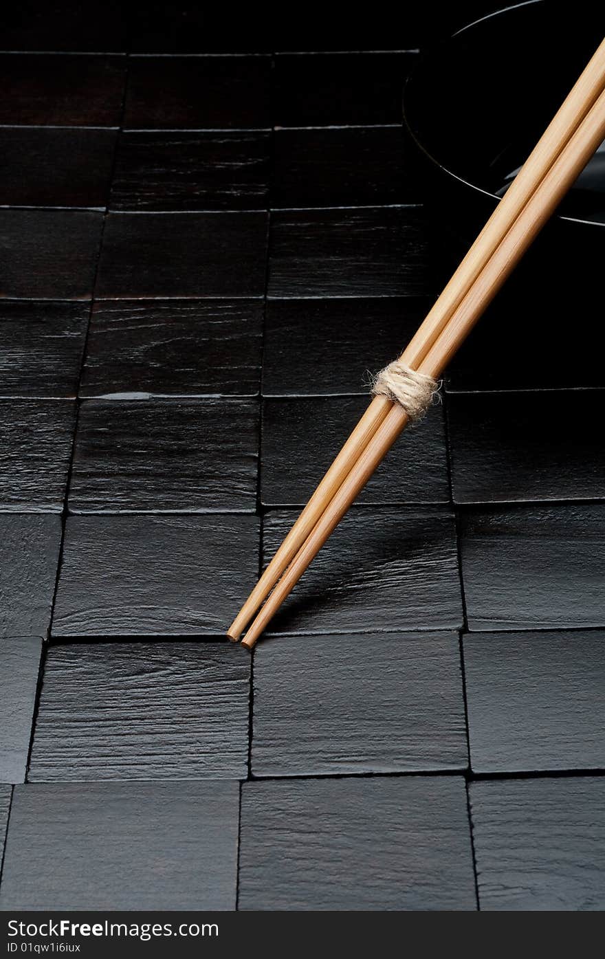 Chopsticks resting on a black bowl