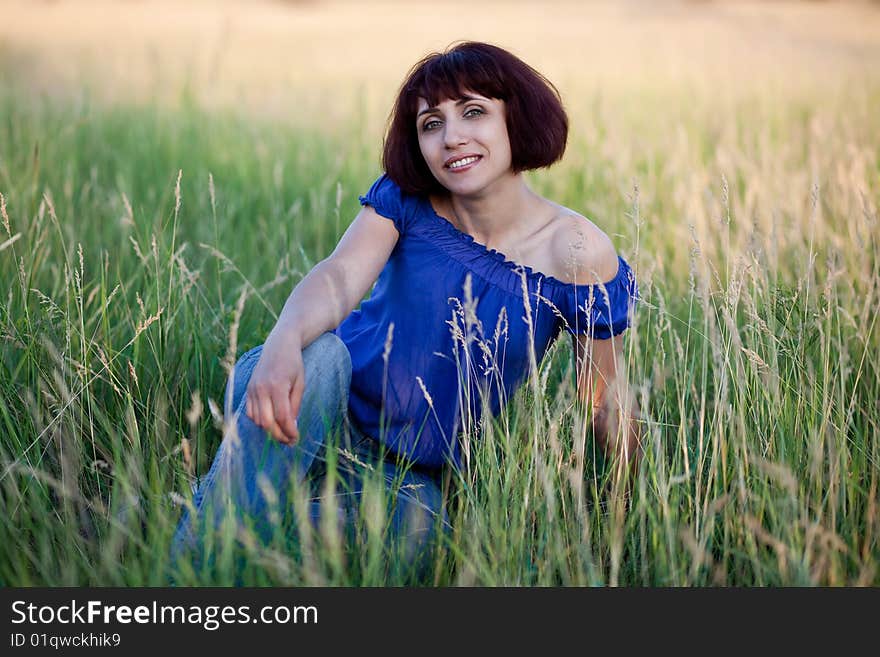 Woman sits in a grass