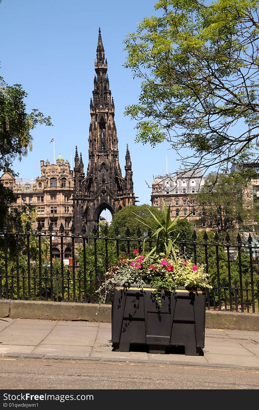 The Scott Monument on Edinburgh's Princes Street with a colourful floral tub in the foreground. The Scott Monument on Edinburgh's Princes Street with a colourful floral tub in the foreground.