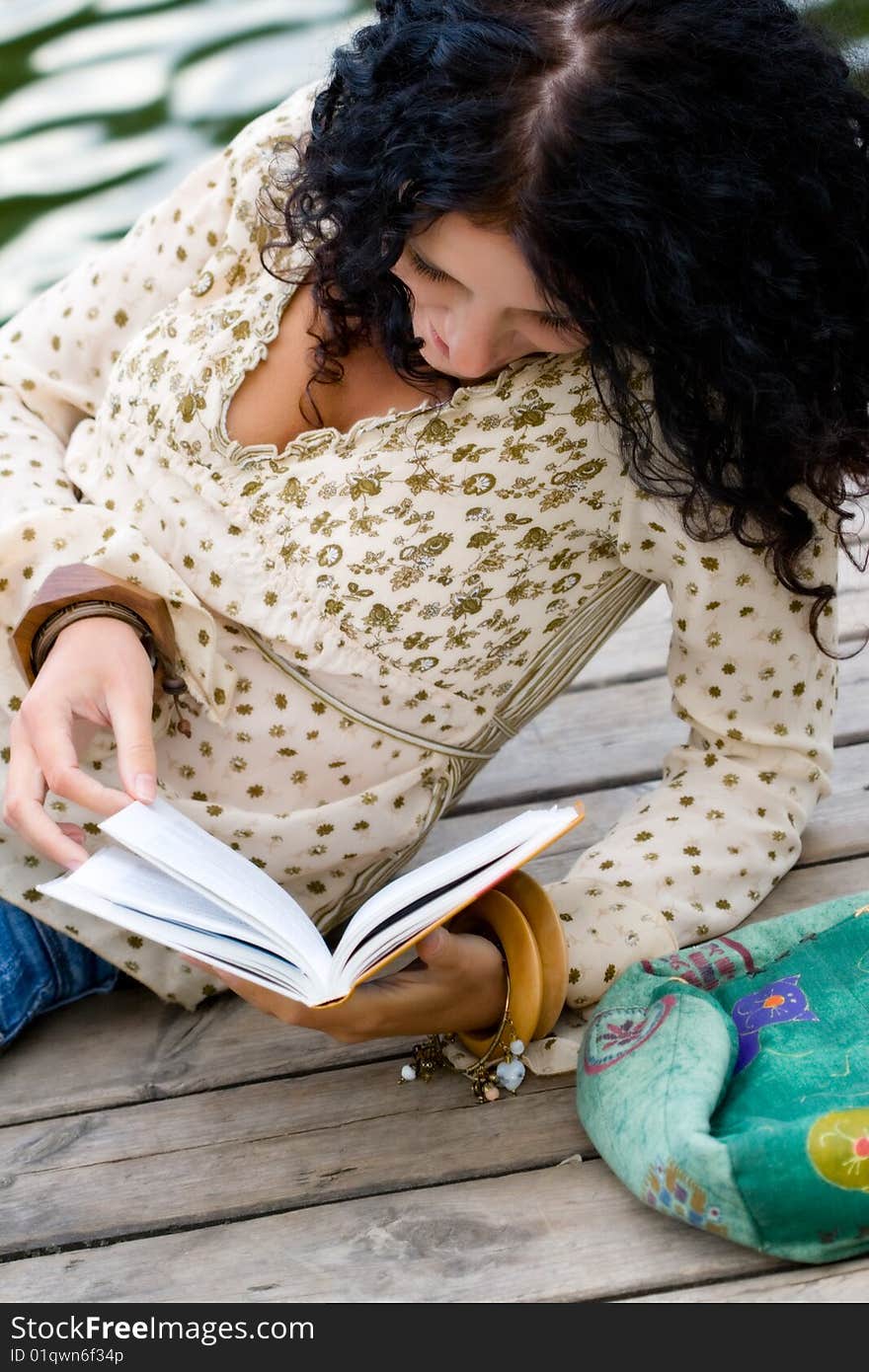 Outdoor portrait of a beautiful woman reading a book