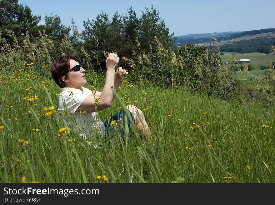 A woman sitting on a hill and enjoying summer time. Ontario, Toronto. A woman sitting on a hill and enjoying summer time. Ontario, Toronto.