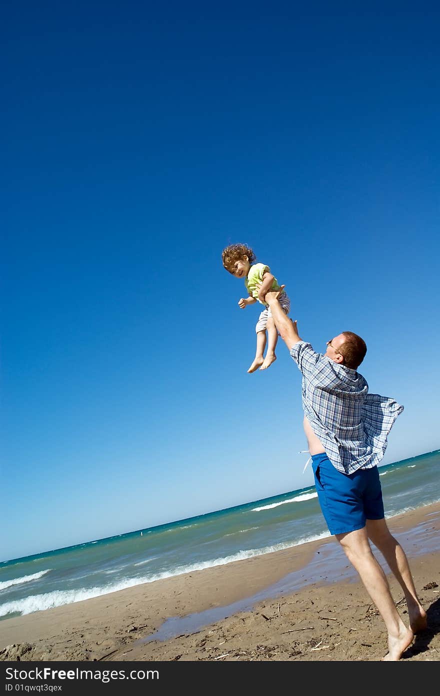 A father throws his little girl into the air. A father throws his little girl into the air