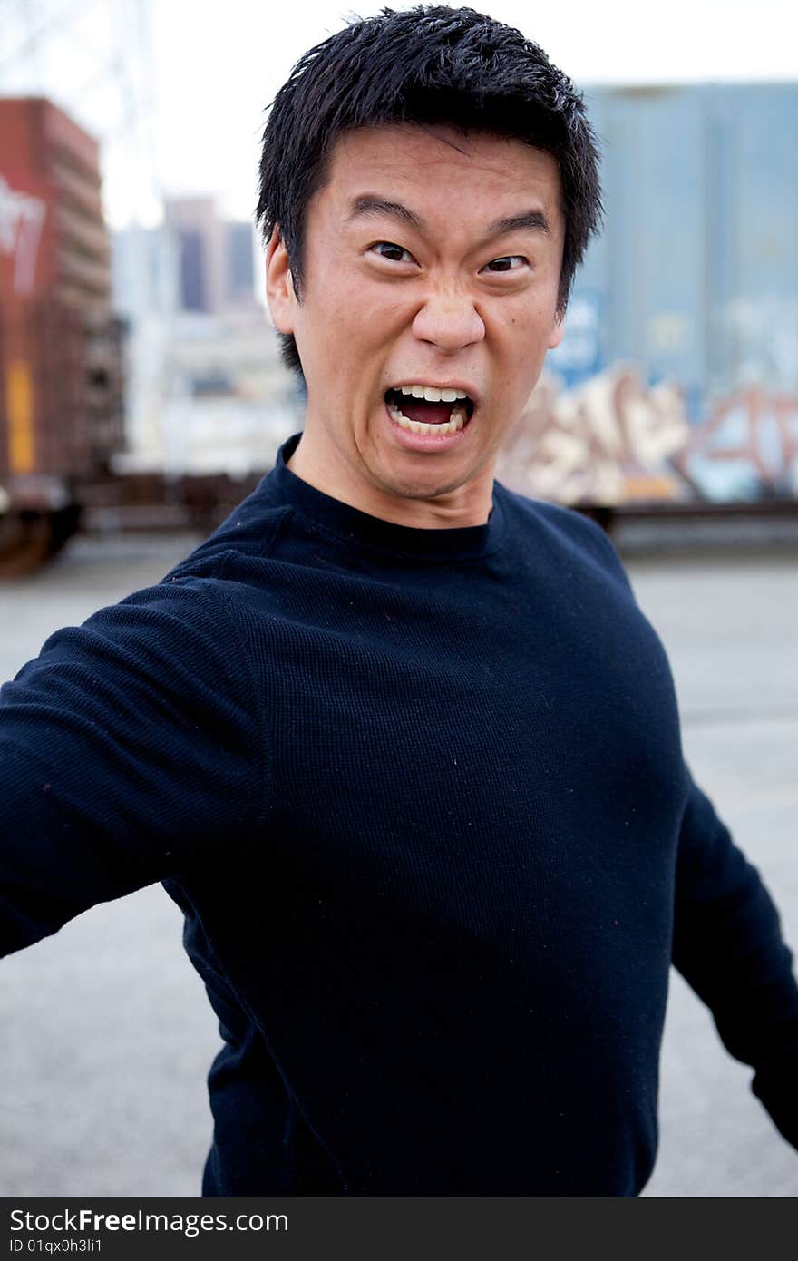 An angry asian man performing karate moves toward the camera. An angry asian man performing karate moves toward the camera