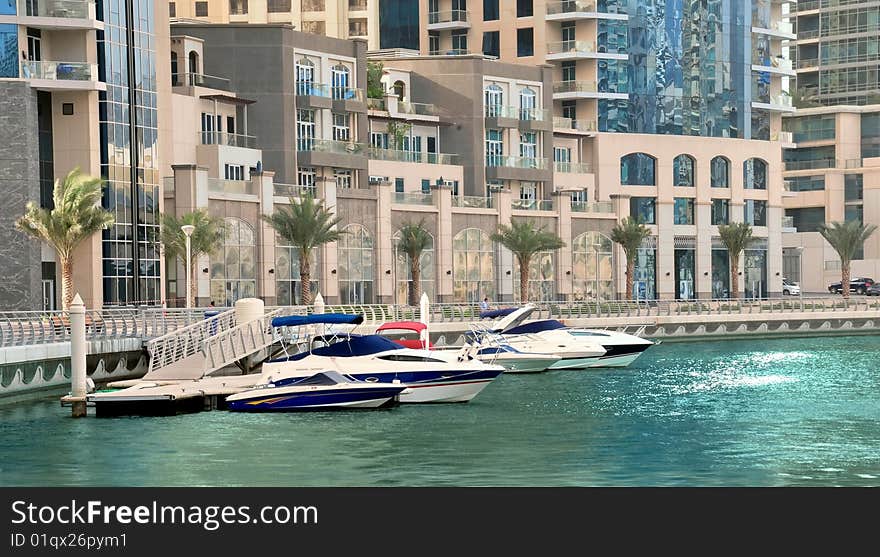 Dubai Luxury Apartments at the Marina with boats berthing infront of them.