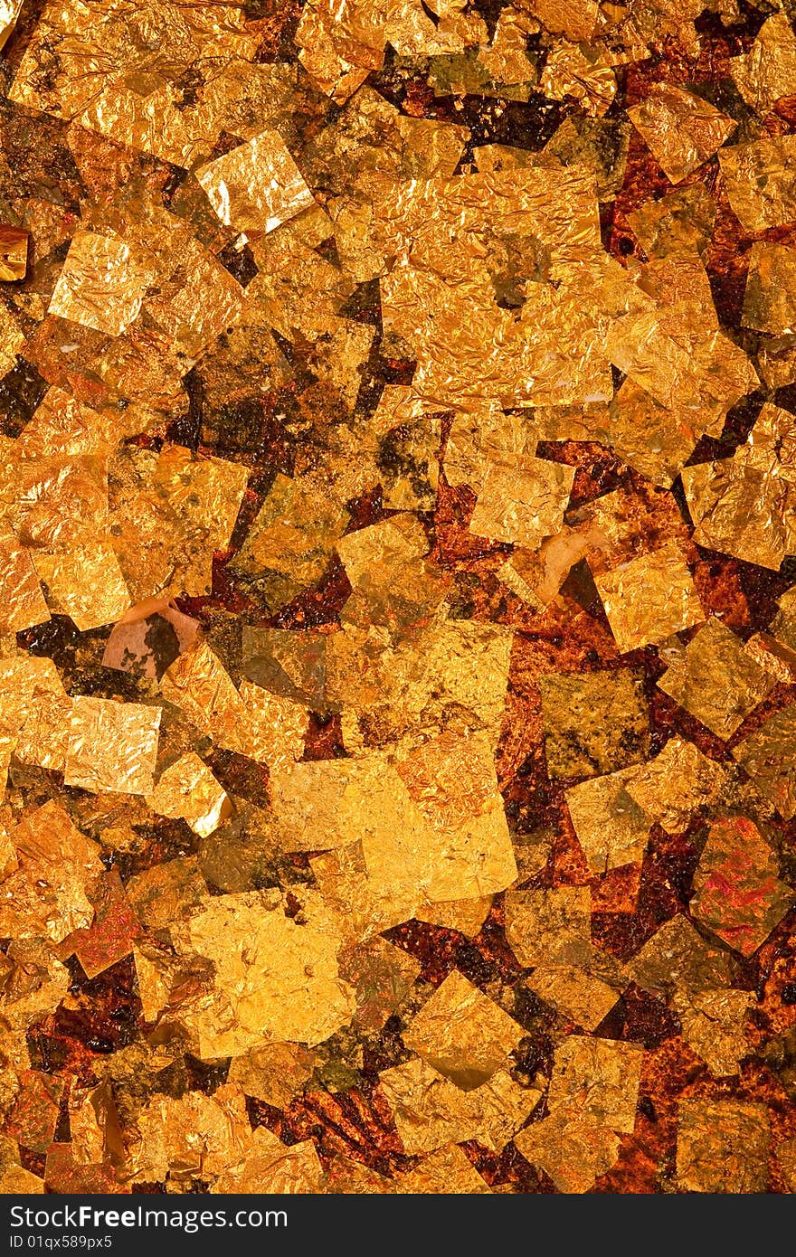 Gold leaves over base of reclining Buddha image