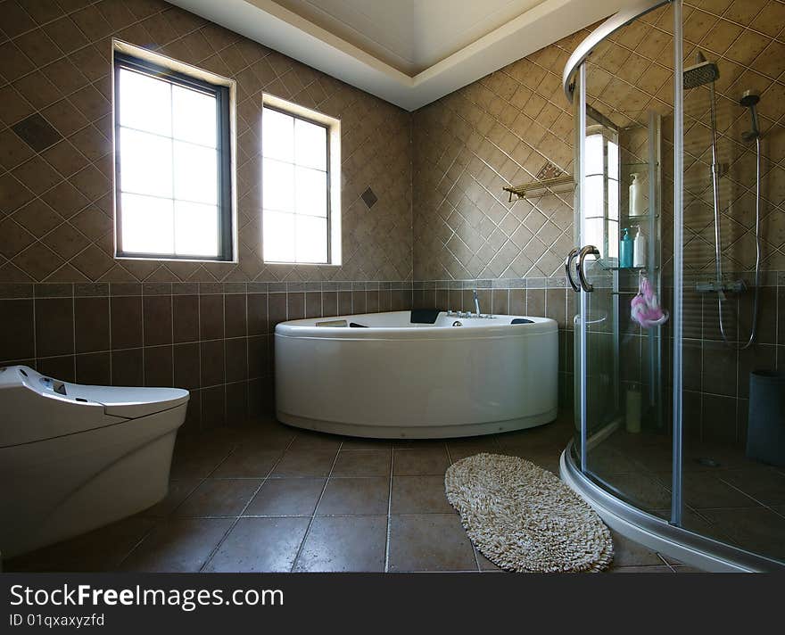 Bright and comfortable modern bathroom with curved tub and shower. Bright and comfortable modern bathroom with curved tub and shower.