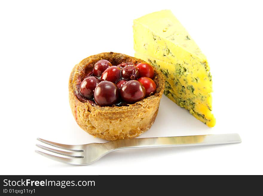 Pork pie and slice of blue cheese with fork and clipping path on a white background. Pork pie and slice of blue cheese with fork and clipping path on a white background