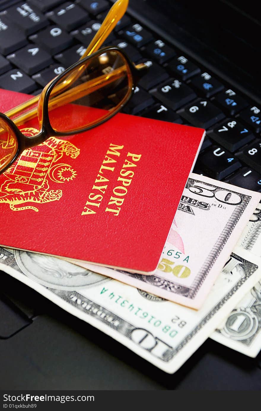 International Travel Passport with Currency put on top computer. International Travel Passport with Currency put on top computer