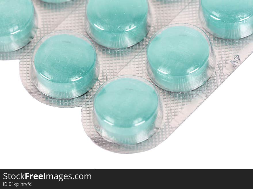 Close up of blue pills on a white background