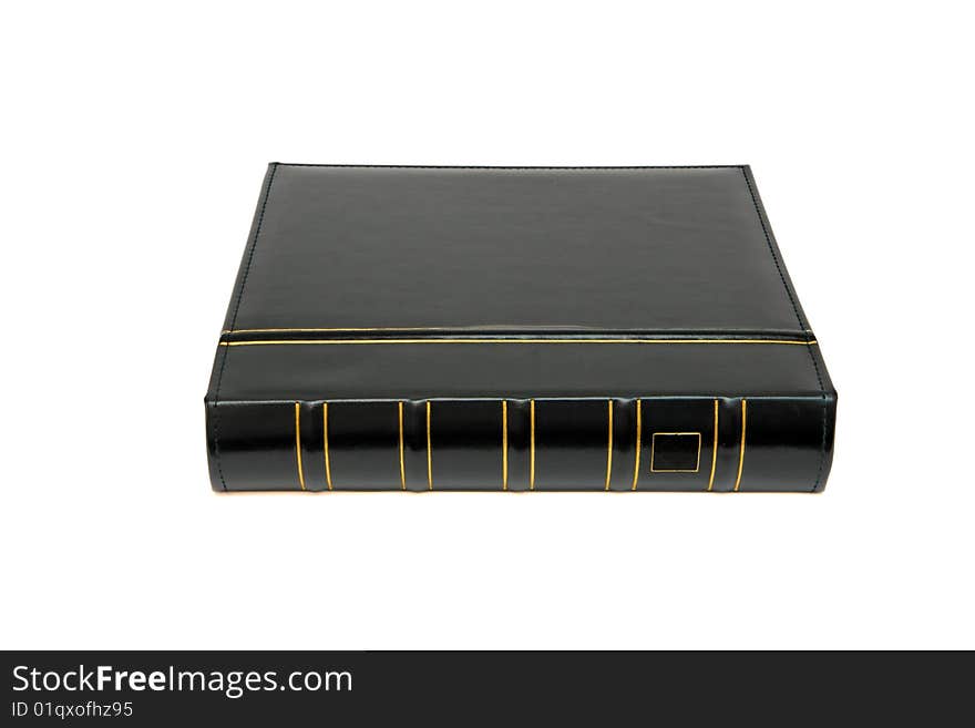 Thick black book with golden trimming laid on white background. Thick black book with golden trimming laid on white background