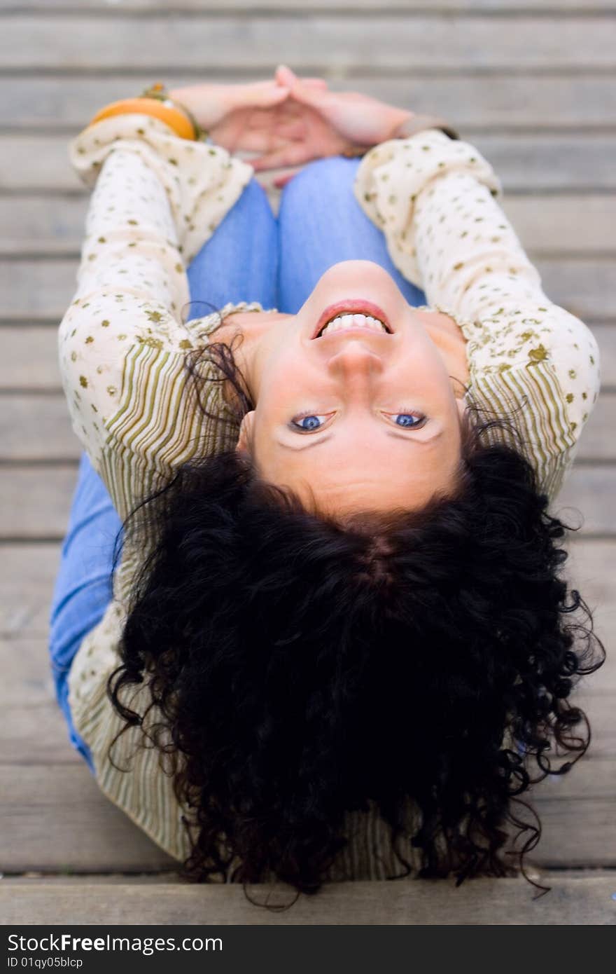 Beautiful brunet woman sitting on wooden floor