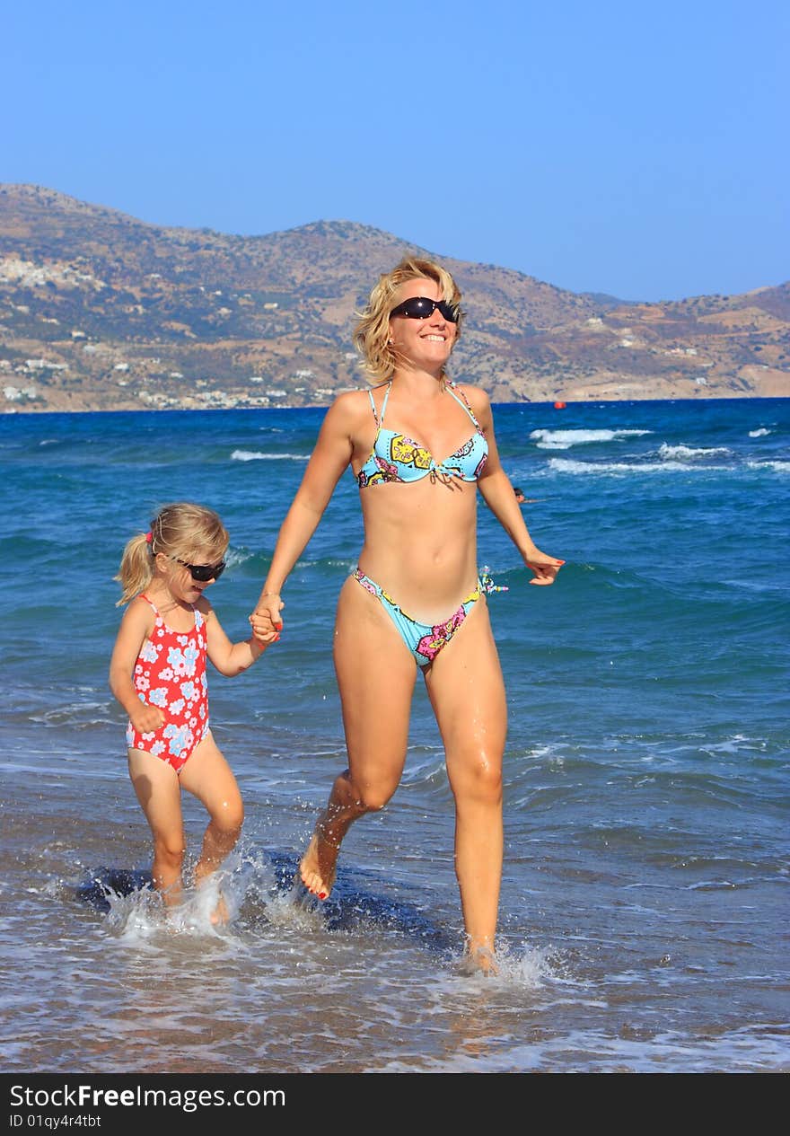 Mother and daughter running on beach. Mother and daughter running on beach