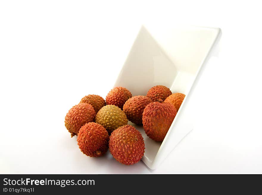 Lychee spilling out a dish with clipping on a white background. Lychee spilling out a dish with clipping on a white background