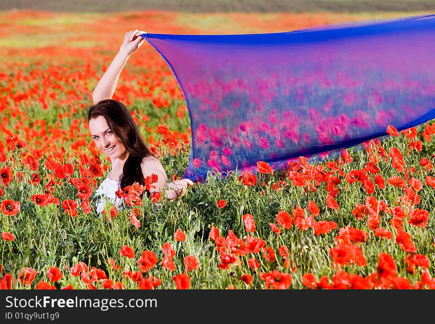 Smiling girl with blue scarf in the poppy field. Smiling girl with blue scarf in the poppy field