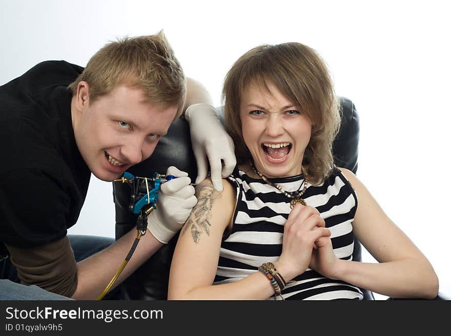 A man drawing tatoo pictures on woman's arm. A man drawing tatoo pictures on woman's arm