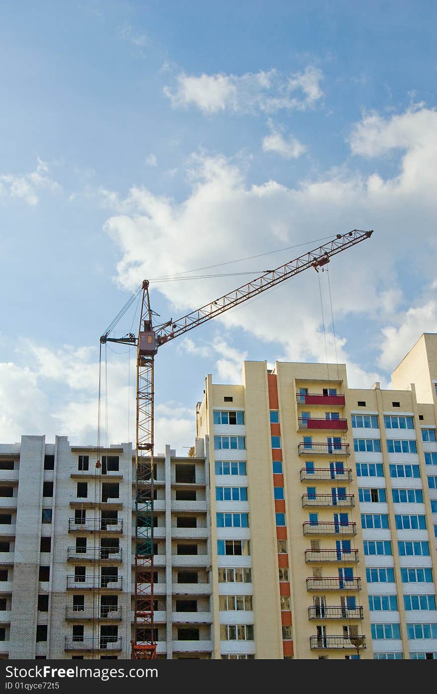 Tower crane on the construction site over blue sky