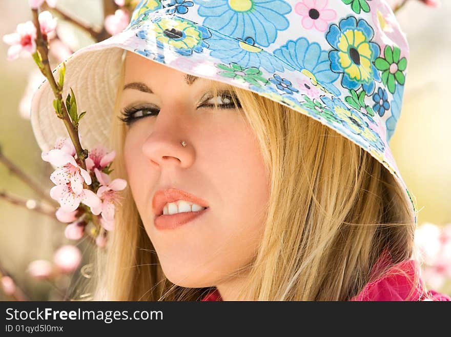 Closeup portrait of young woman over blossom trees. Closeup portrait of young woman over blossom trees