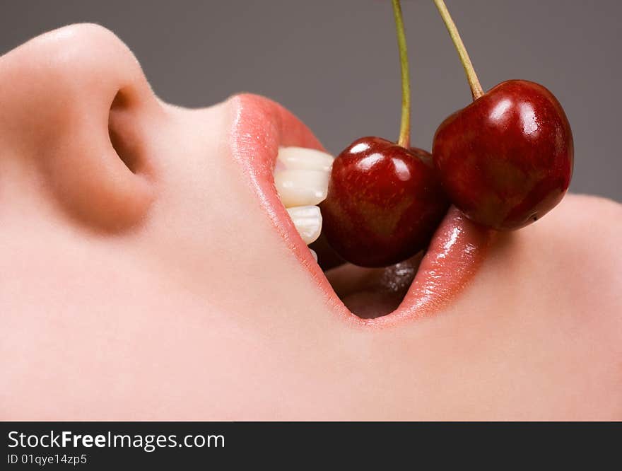 Healthy young woman eating red cherries