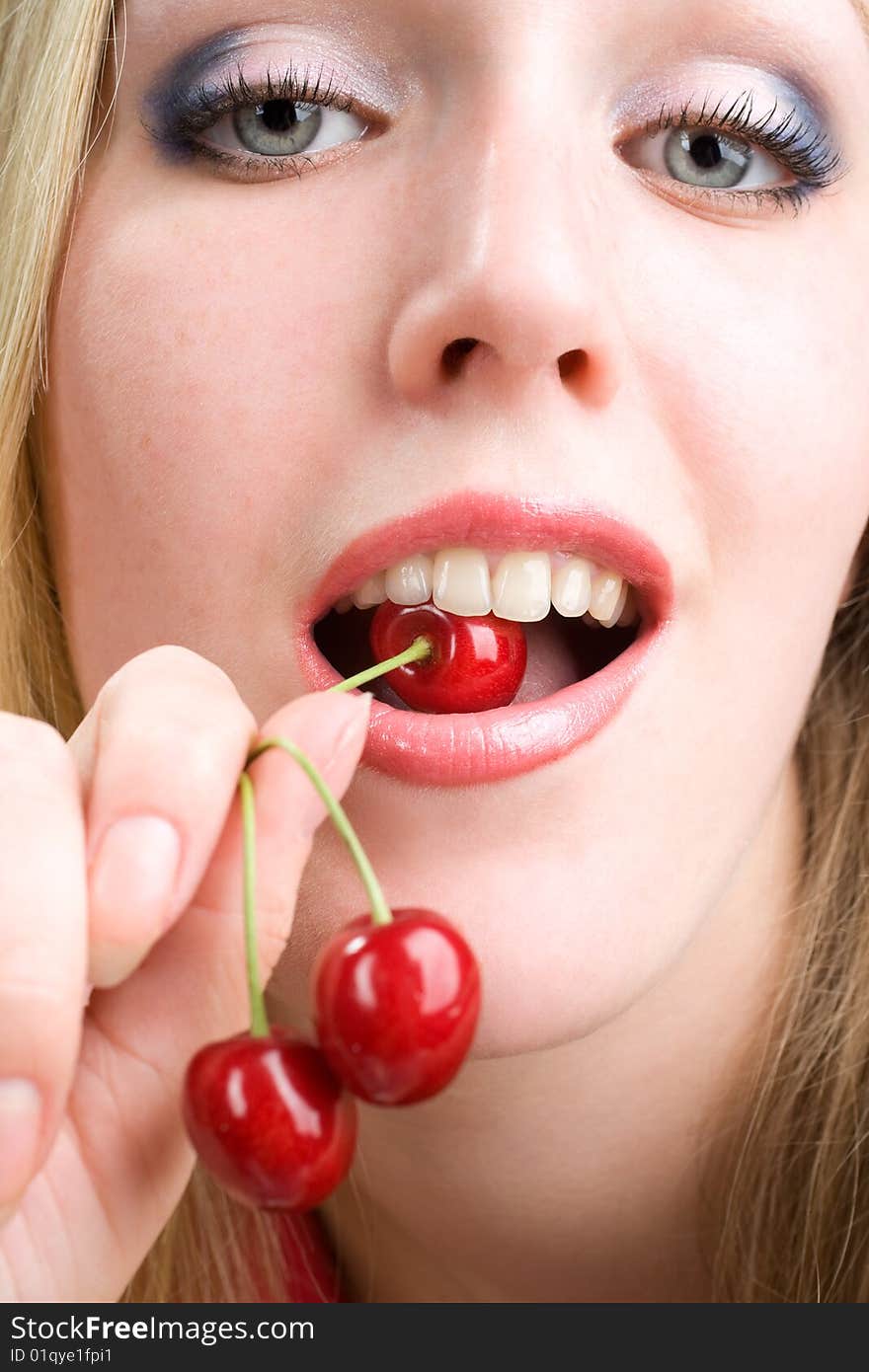 Healthy young woman eating red cherries