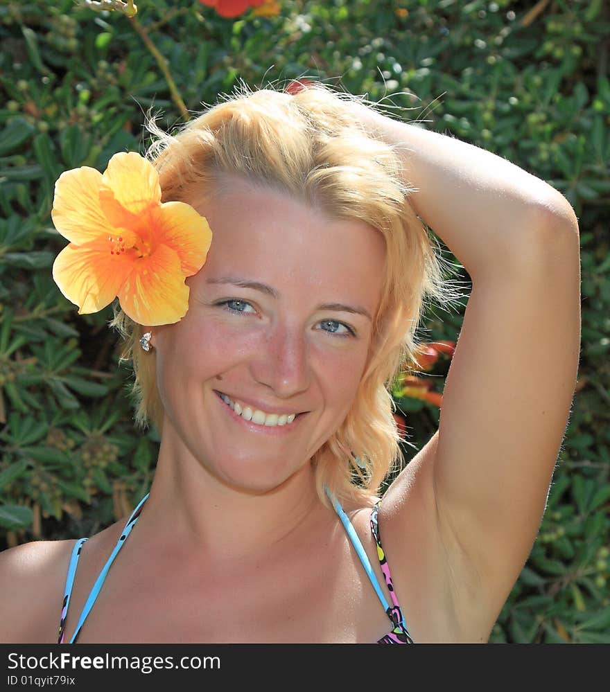 Portrait of the beautiful woman with a flower in hair